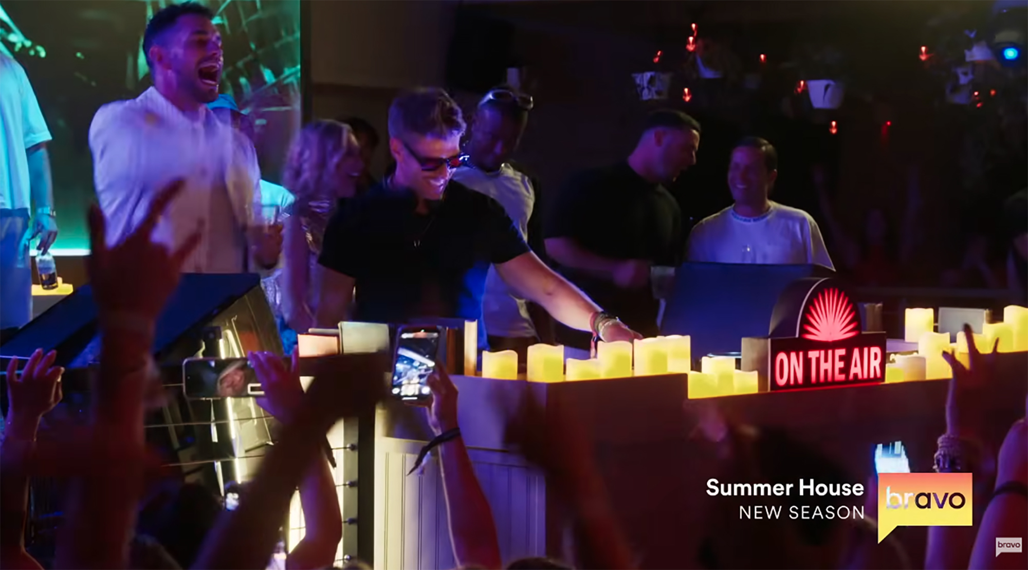 Kyle Cooke, a DJ, at a party with a crowd of people.