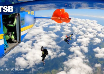 Video shows skydiver dangling from plane after parachute gets caught