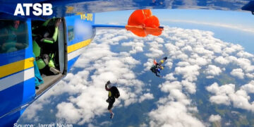 Video shows skydiver dangling from plane after parachute gets caught