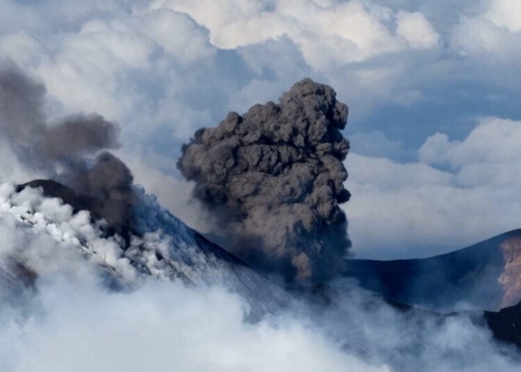 Skier glides down Mount Etna as volcano erupts in the background