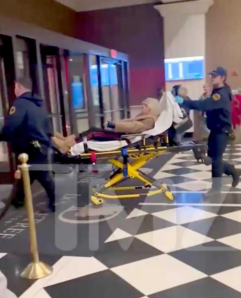 Tara Reid on a stretcher being moved by paramedics.