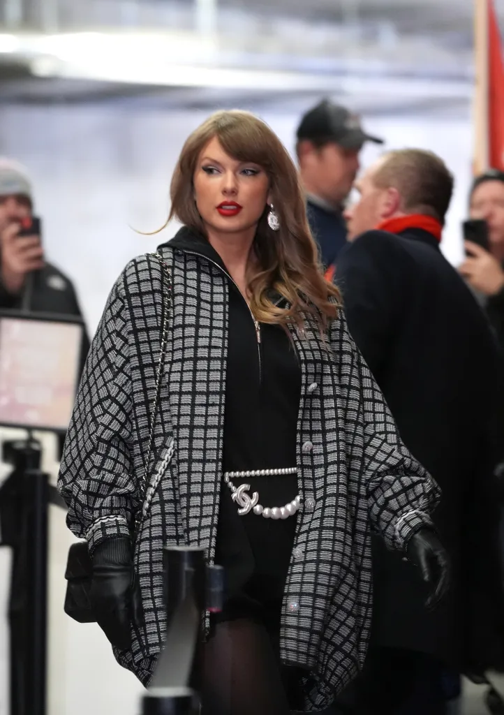 Taylor Swift arriving at the AFC Divisional Playoff game in a black and white checkered jacket.