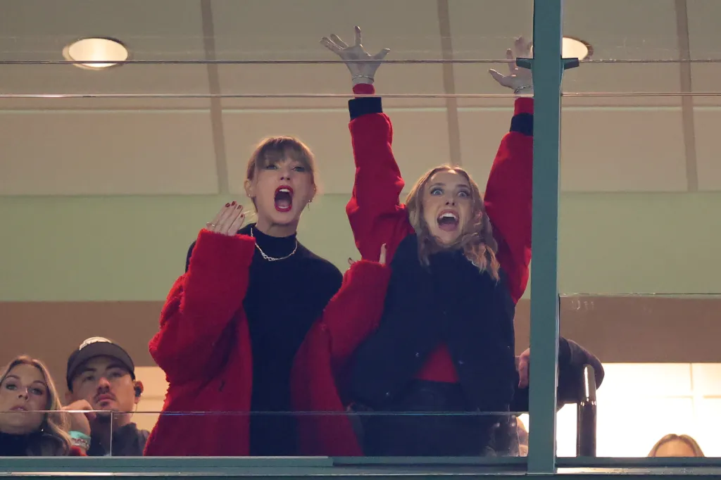 Taylor Swift and Brittany Mahomes in a suite cheering at a game.