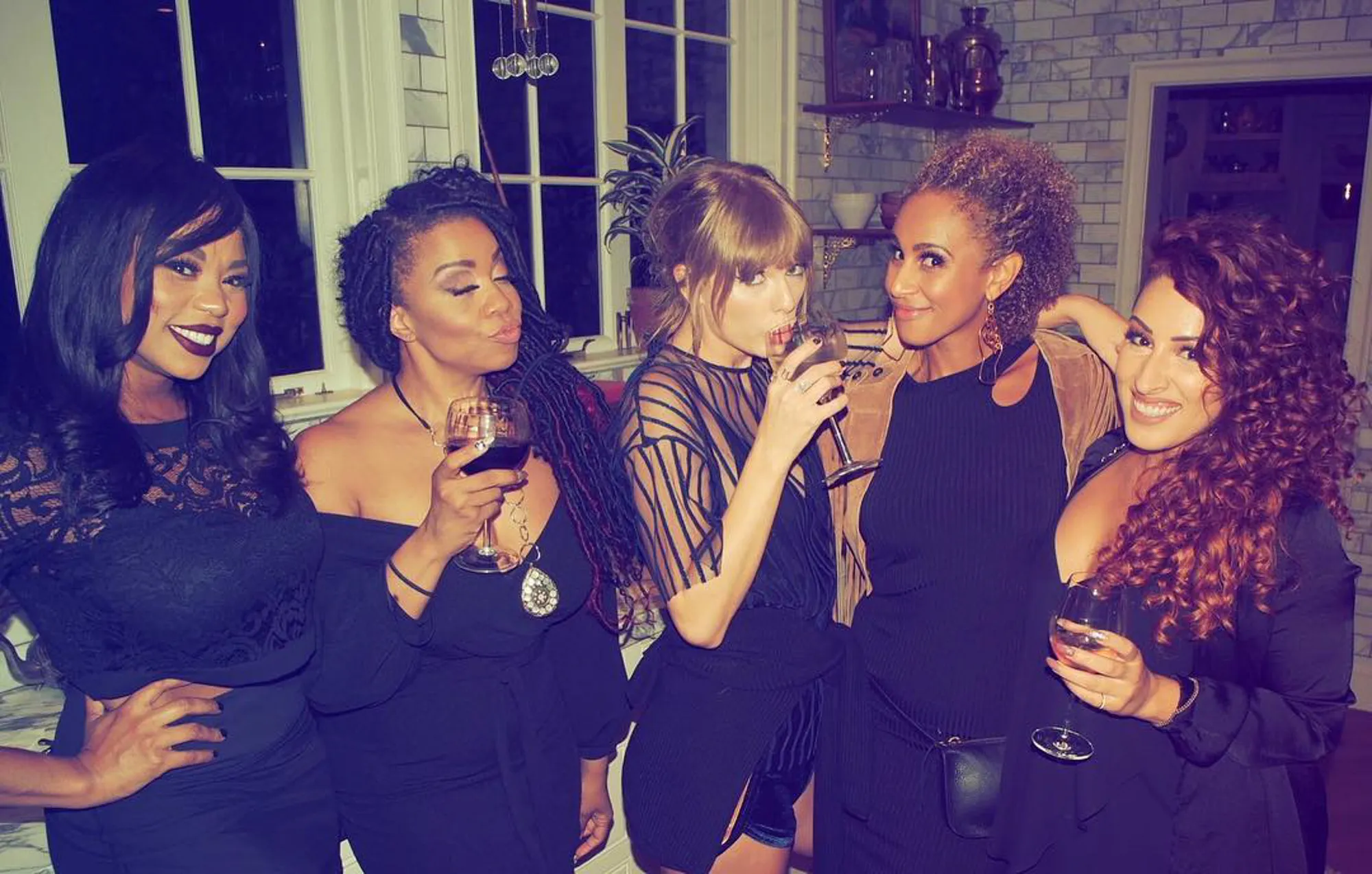 Taylor Swift and her dancers celebrating together.
