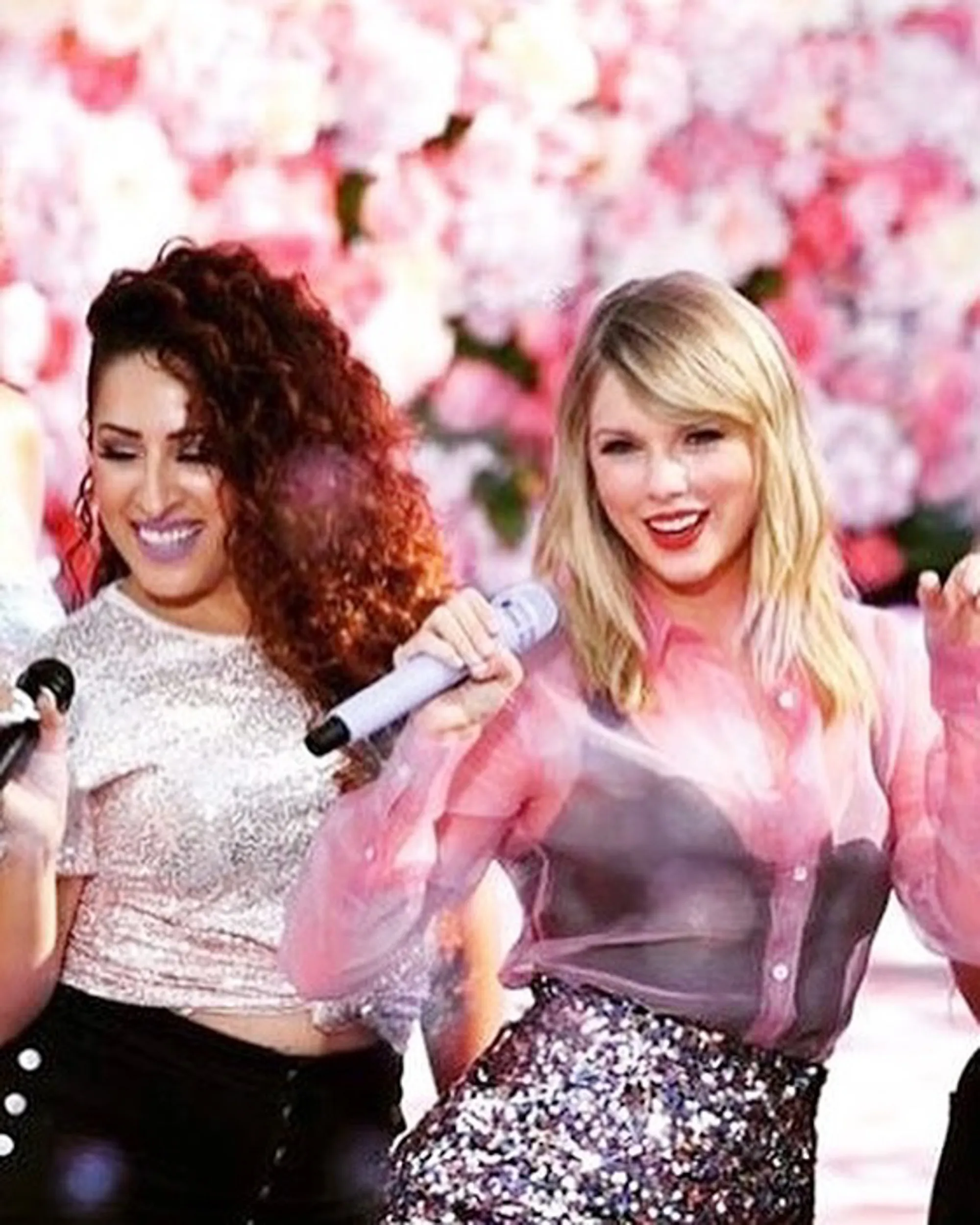 Taylor Swift and another woman singing with microphones.
