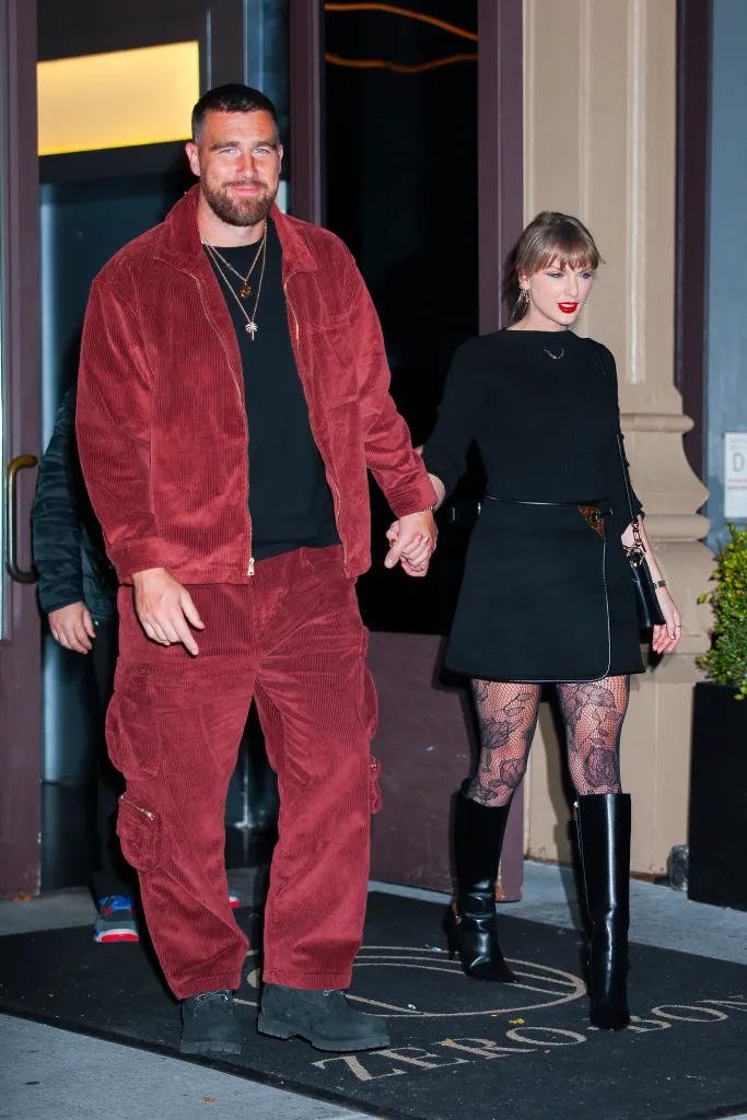 Taylor Swift and Travis Kelce holding hands while walking in New York City.