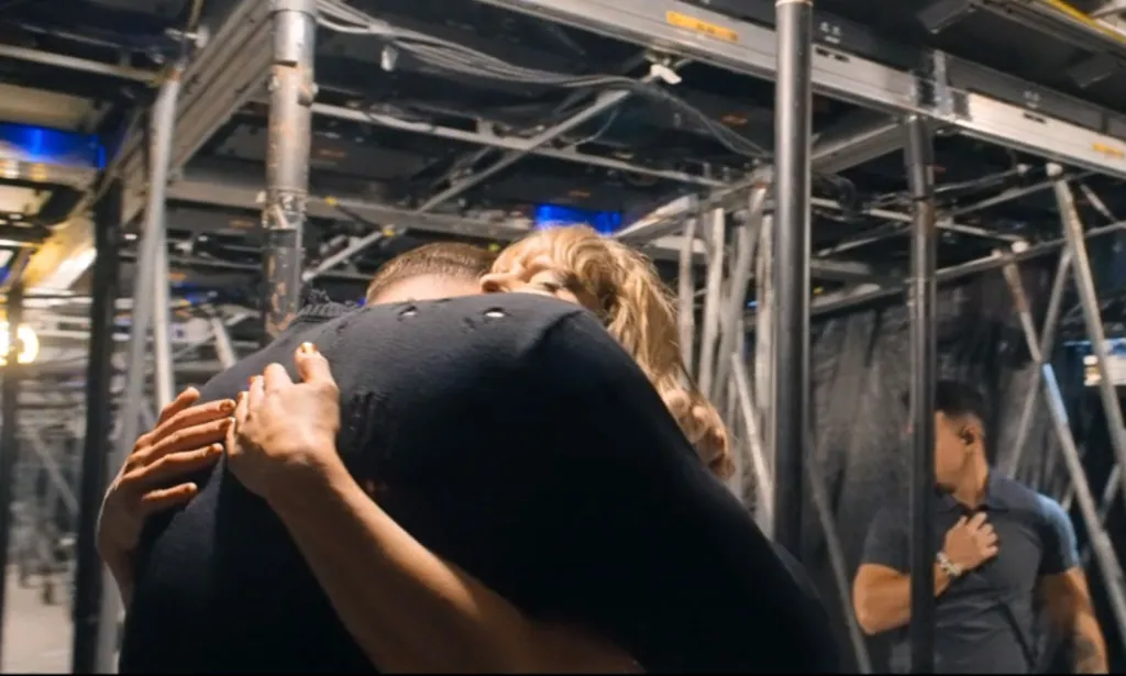 Taylor Swift and Travis Kelce sharing a hug backstage during the Eras Tour.