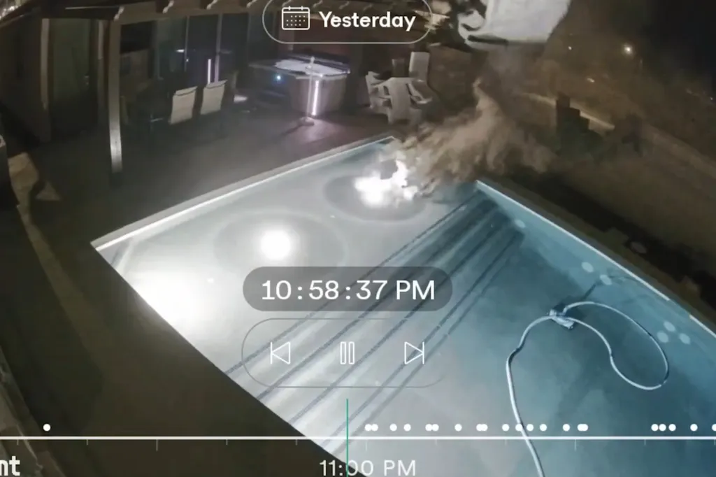 The speeding car destroys a portion of the brick wall near the pool.