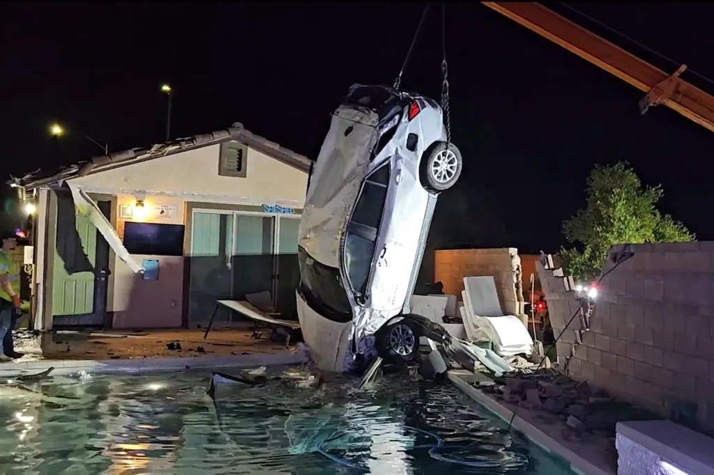 Crews lift the car out of Reed's pool after the crash.