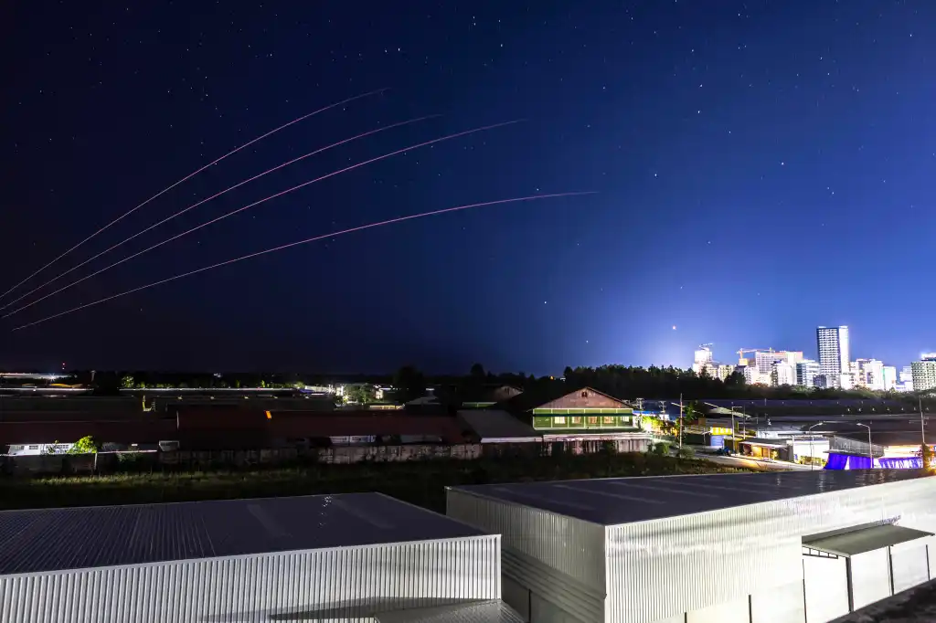 Artillery fire creating red streaks in the night sky over Sa Kaeo Province, Thailand.