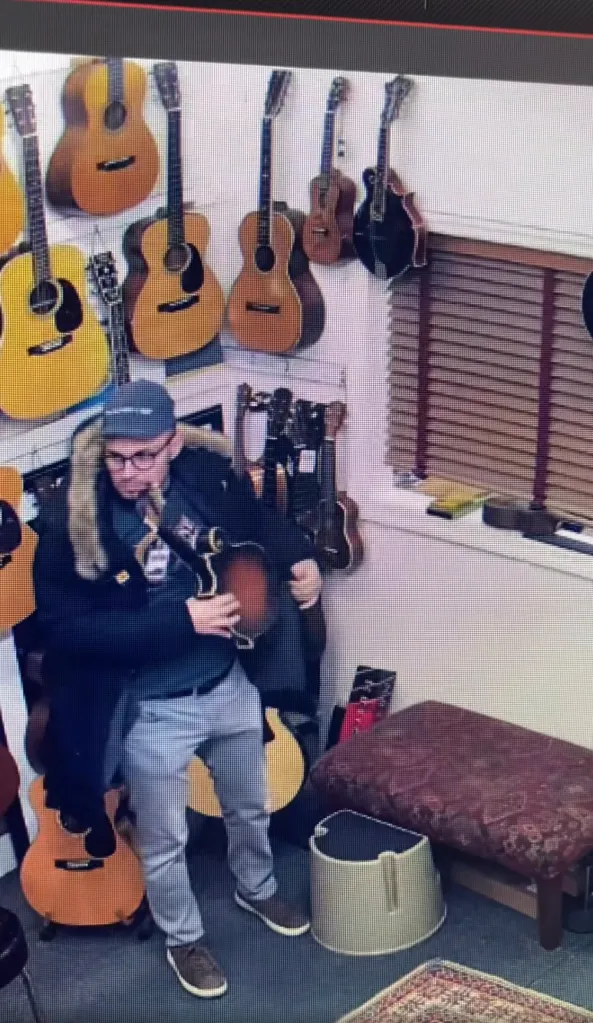 A man stealing mandolins in a music store.