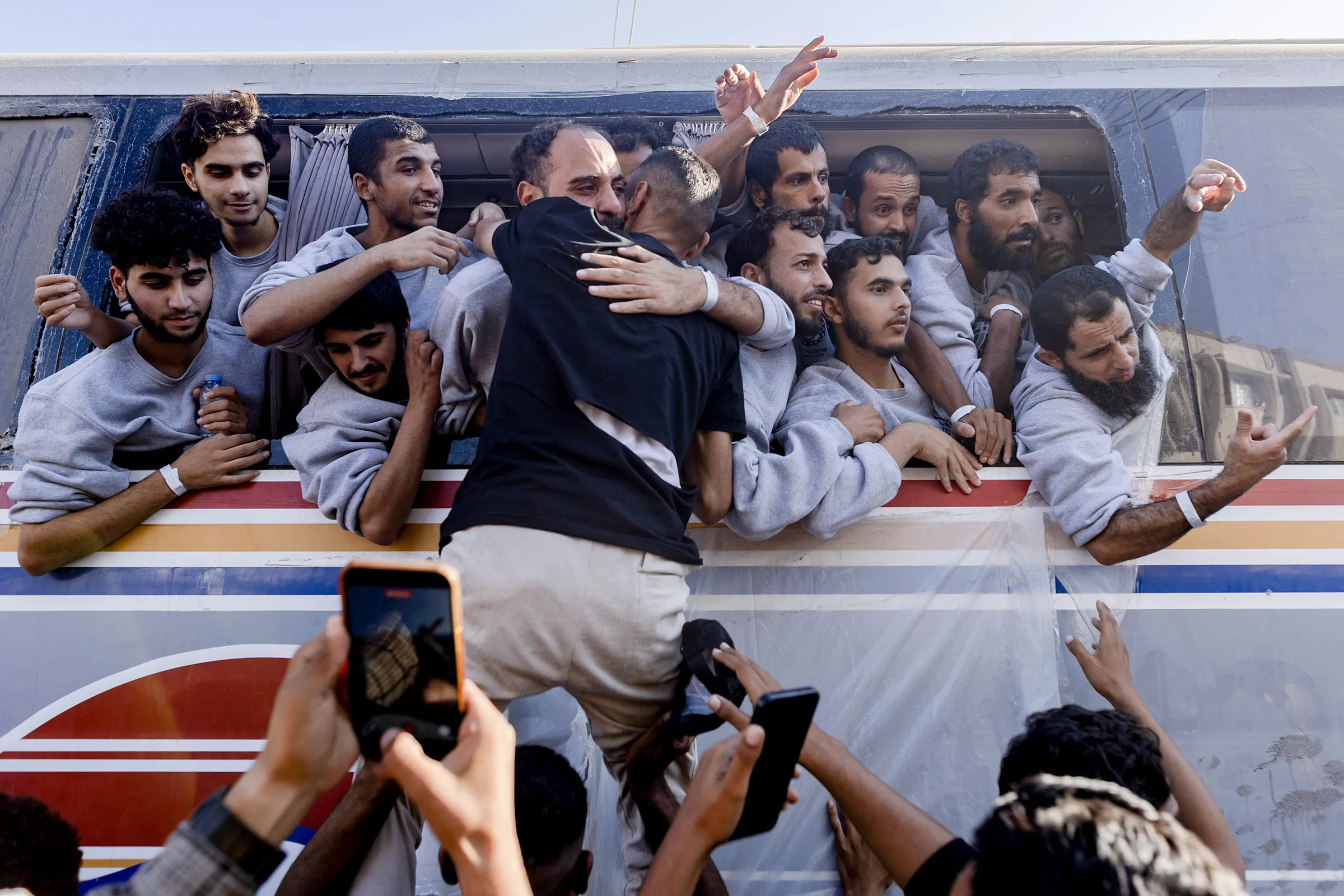 Palestinian prisoners released by Israel wave from a bus as they arrive at Nasser Hospital in Khan Younis, in southern Gaza, on Monday, Oct. 13, 2025. (Saher Alghorra/The New York Times)