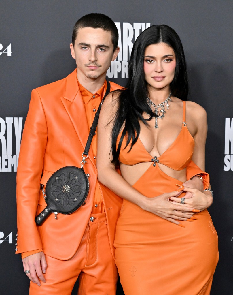 Timothée Chalamet in an orange suit and Kylie Jenner in an orange dress with cross-shaped accents at the premiere of 