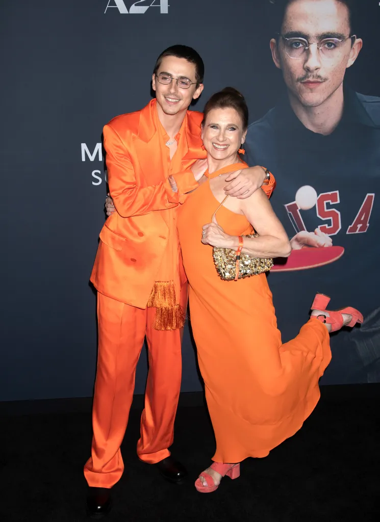 Timothee Chalamet and Nicole Flender in orange outfits.