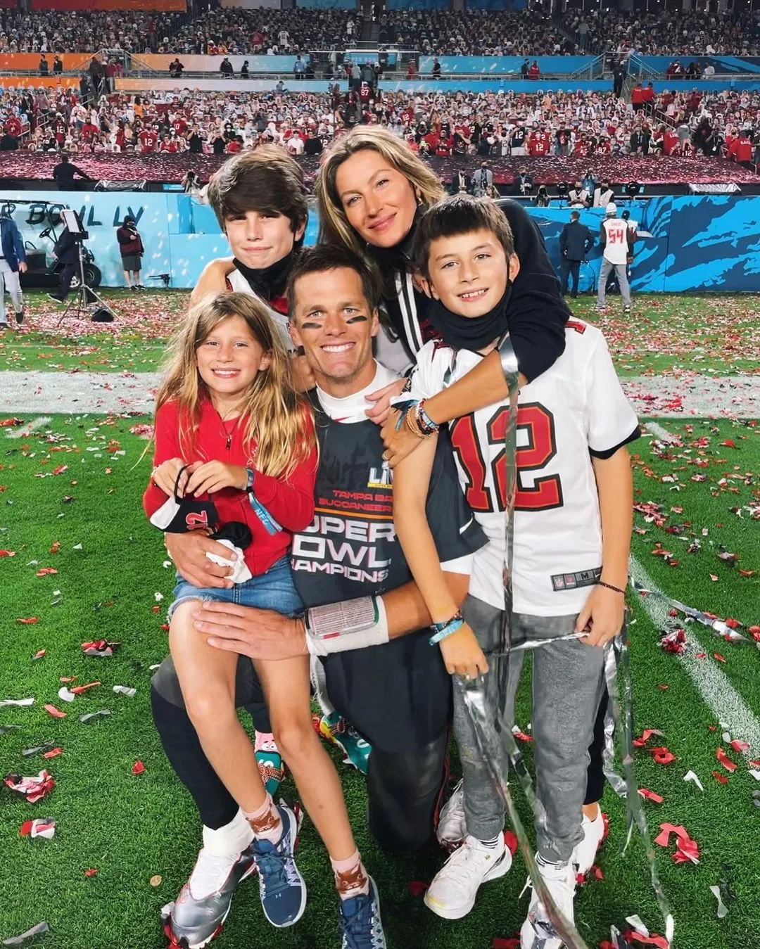 Tom Brady, Gisele Bündchen, and their children, Vivian, Benjamin, and Jack, on a football field covered in confetti.
