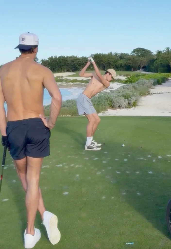 Tom Brady and his son Jack playing shirtless golf on a course near the water.