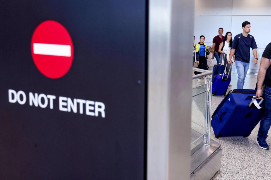 Travelers arrive at Miami International Airport as a