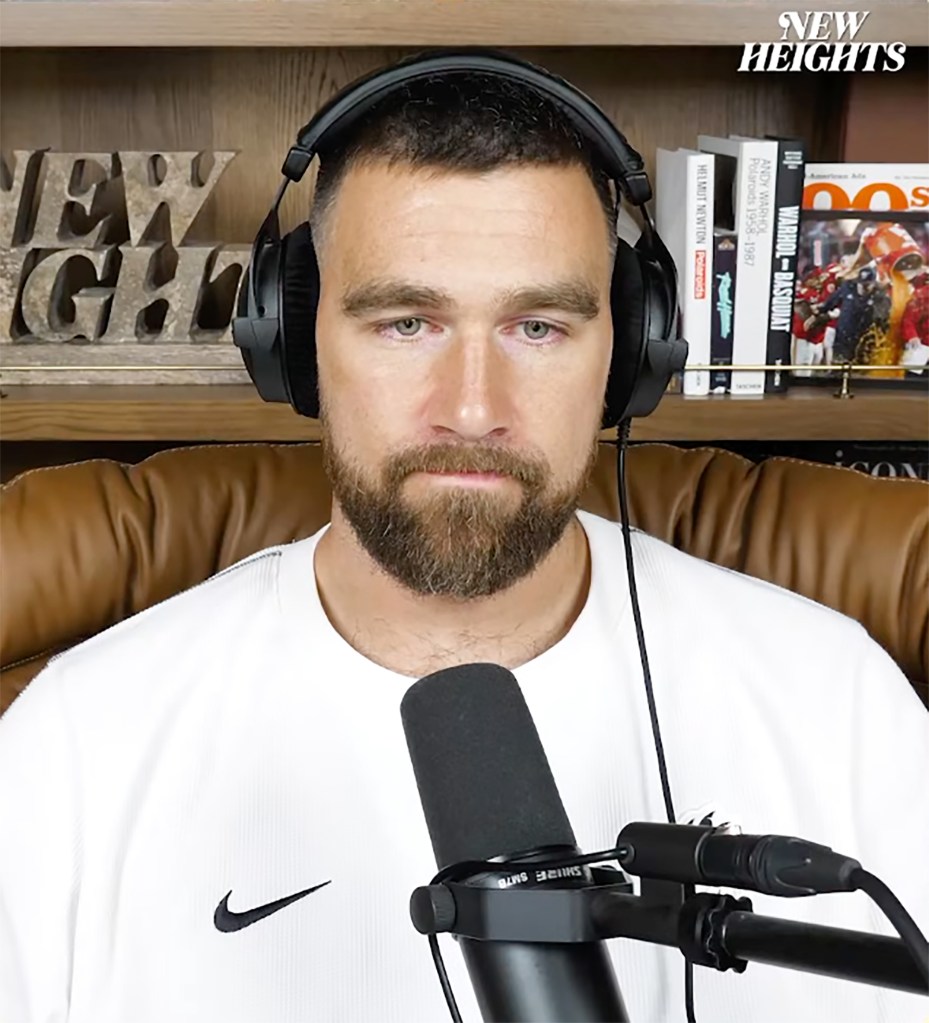 Travis Kelce wearing headphones and a white Nike shirt on the New Heights podcast.