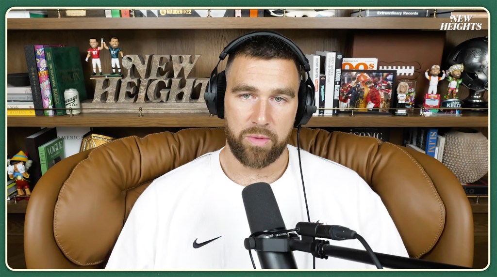 Travis Kelce speaking into a microphone on the New Heights Podcast.