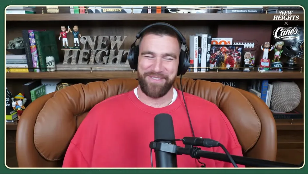 Travis Kelce speaking into a microphone on the 