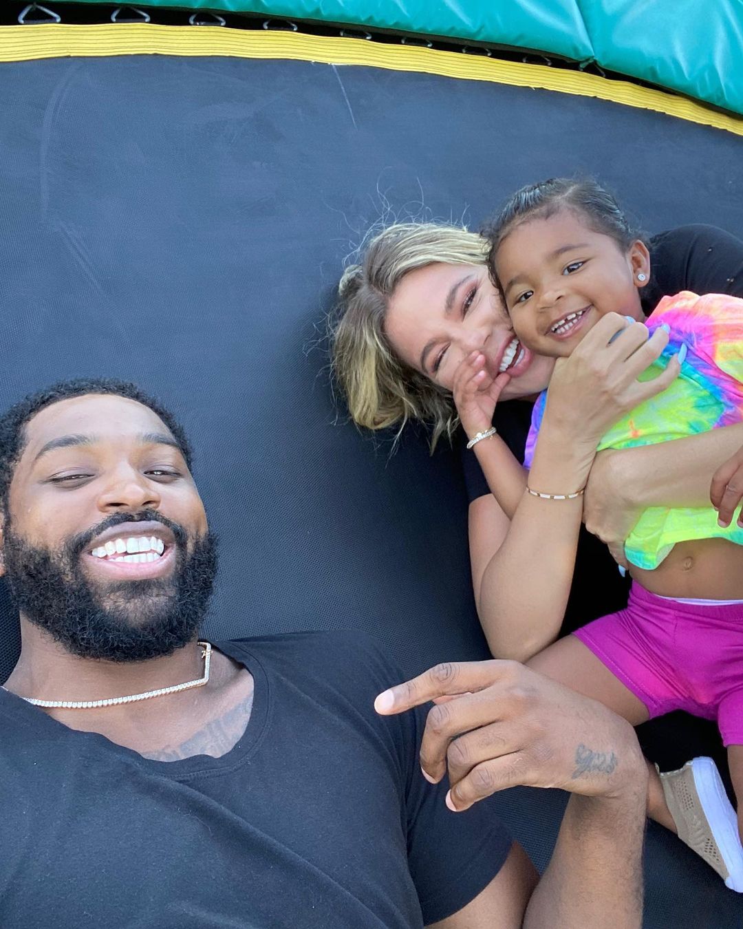 Tristan Thompson, Khloe, and True smiling on a trampoline.