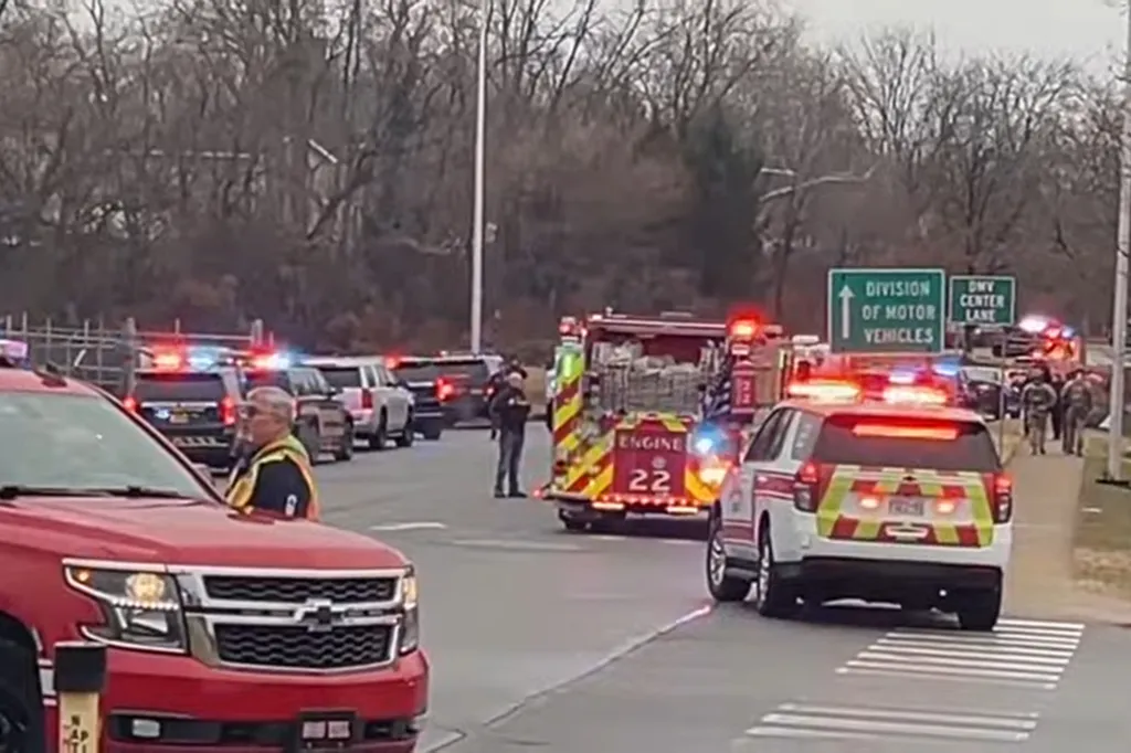 Emergency vehicles, including a fire truck and police cars with flashing lights, at the scene of an incident near the Division of Motor Vehicles.