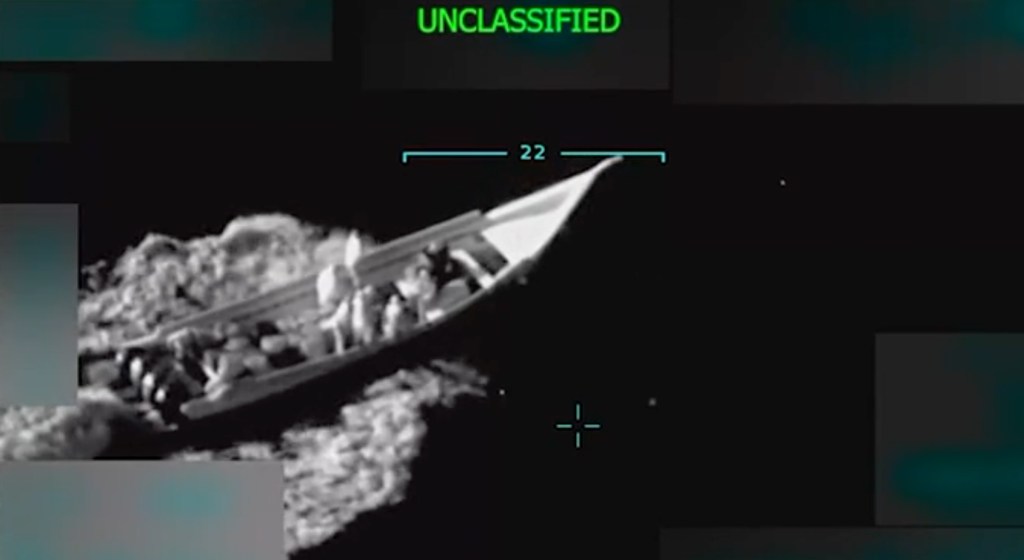 Night-vision footage of a small boat full of people on the water.