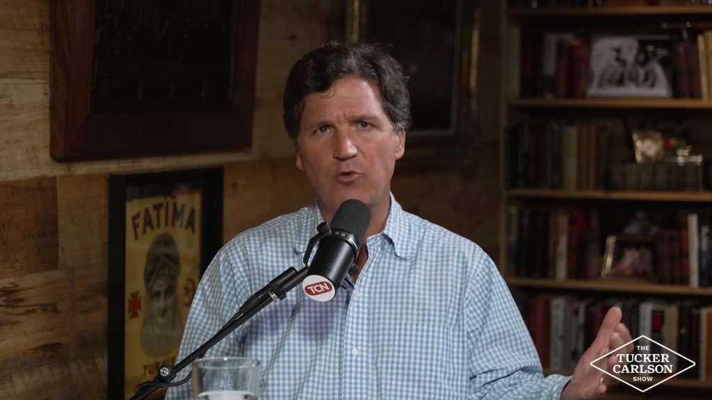 Tucker Carlson speaking into a microphone with