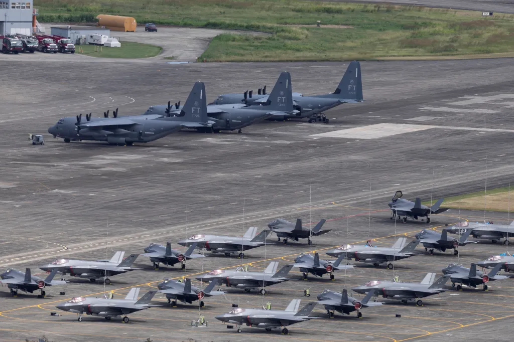 US Marine Corps F-35B and US Air Force F-35A fighter jets parked on an apron near US Air Force HC-130 aircraft in Puerto Rico.