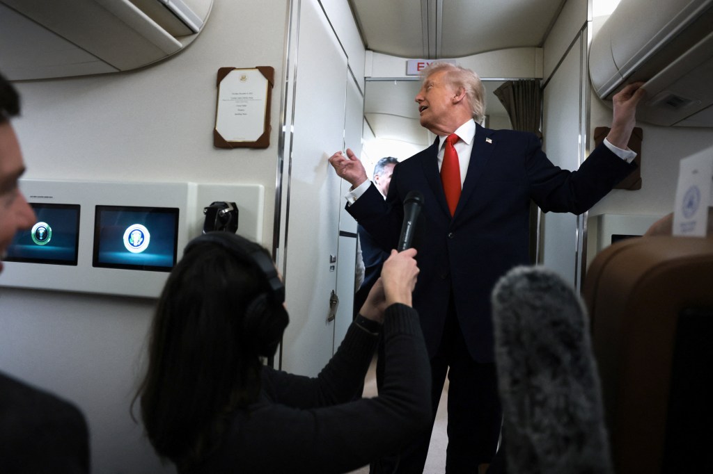U.S. President Donald Trump speaks to reporters aboard Air Force One.