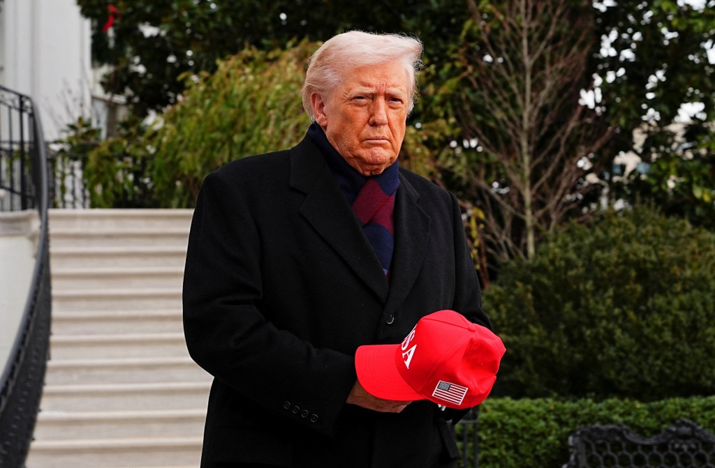 U.S. President Donald Trump holds a red cap before departing for the Army/Navy football game at the White House.