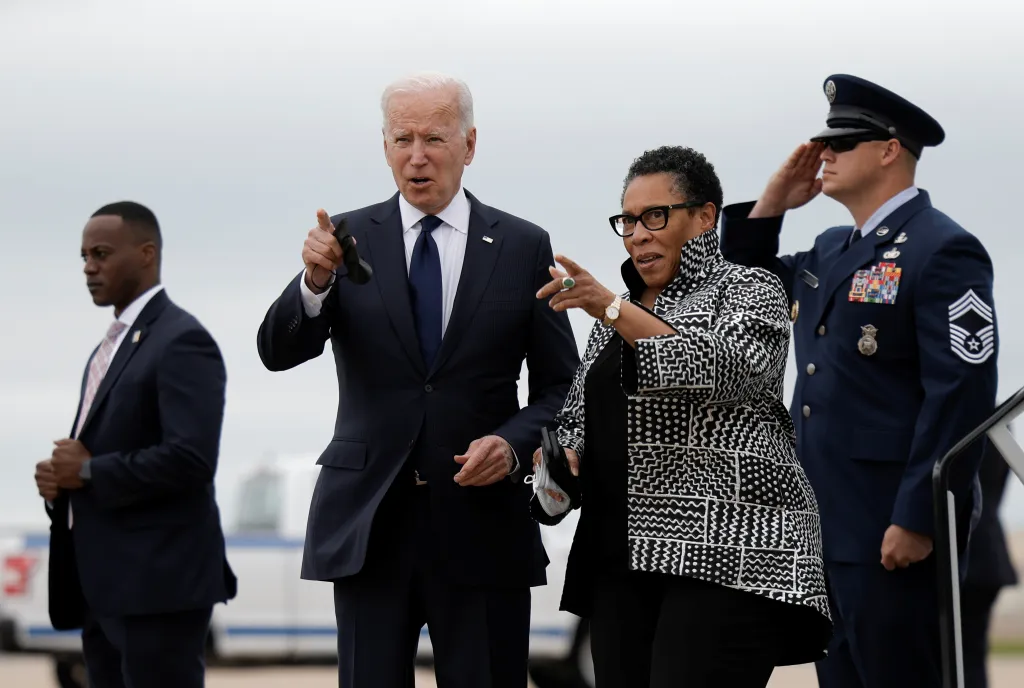 U.S. President Joe Biden and HUD Secretary Marcia L. Fudge arriving at Tulsa International Airport, with a uniformed Air Force officer saluting.