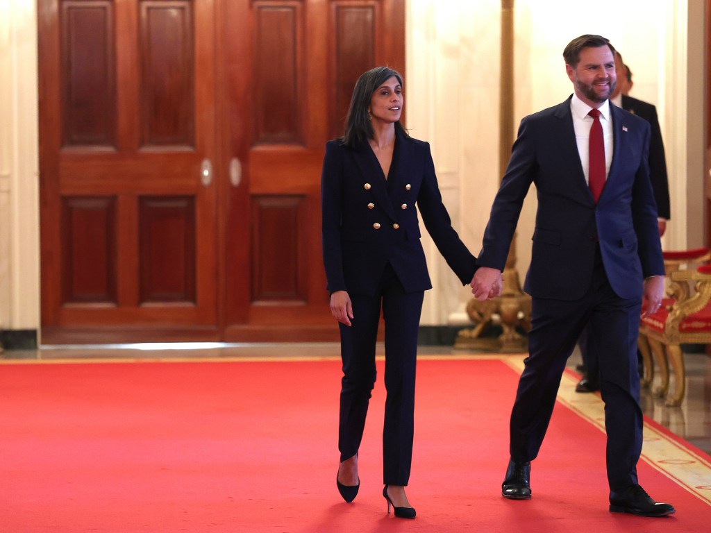 Vice President JD Vance and second lady Usha Vance hold hands as they walk across a red carpet.
