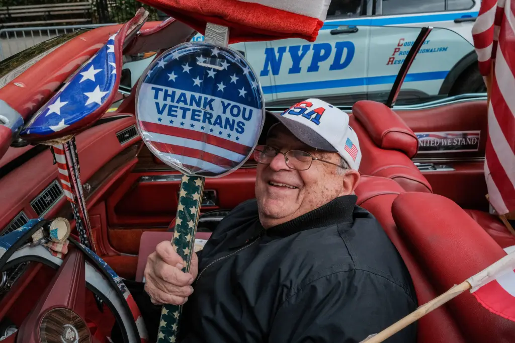 A smiling man in a car, wearing a 