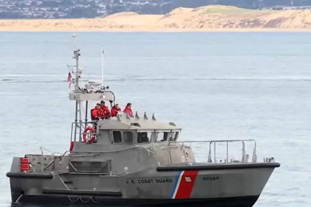 U.S. Coast Guard boat with crew in orange life vests.