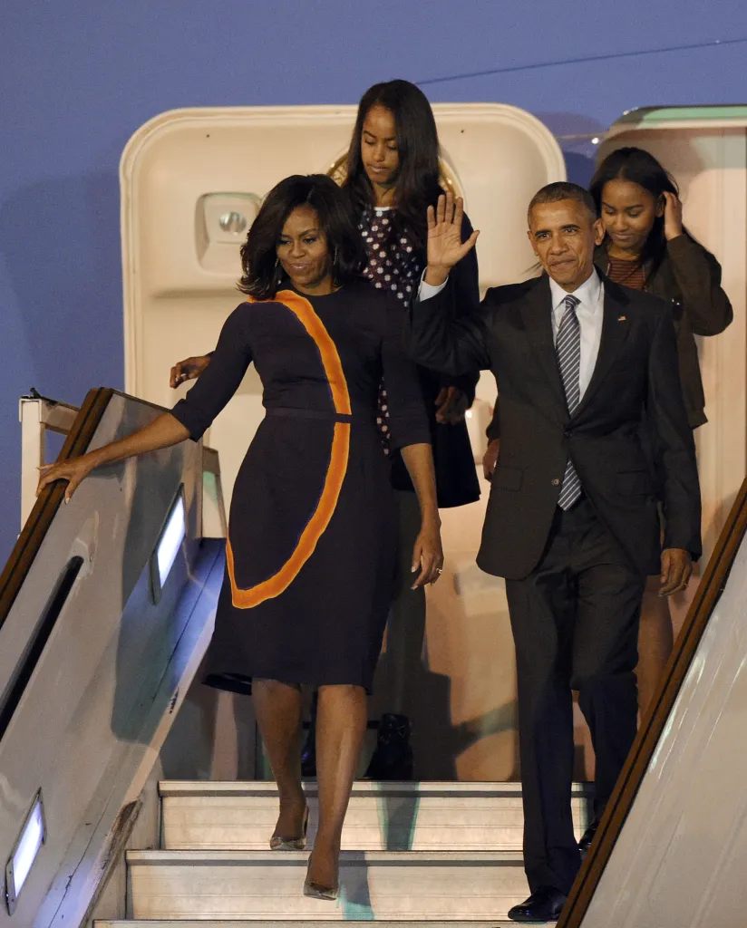 US President Barack Obama, Michelle Obama, and their daughters Sasha and Malia disembarking a plane.