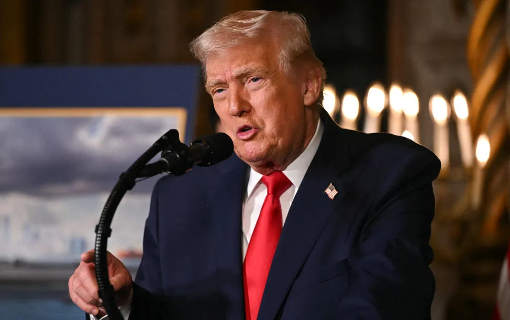 President Donald Trump speaking at a podium with a microphone.