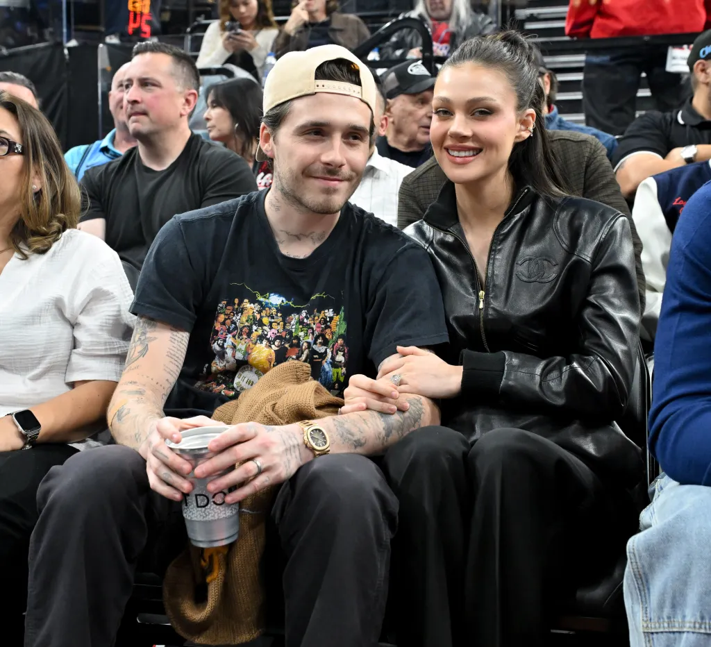 Brooklyn Beckham and Nicola Peltz attend a basketball game.