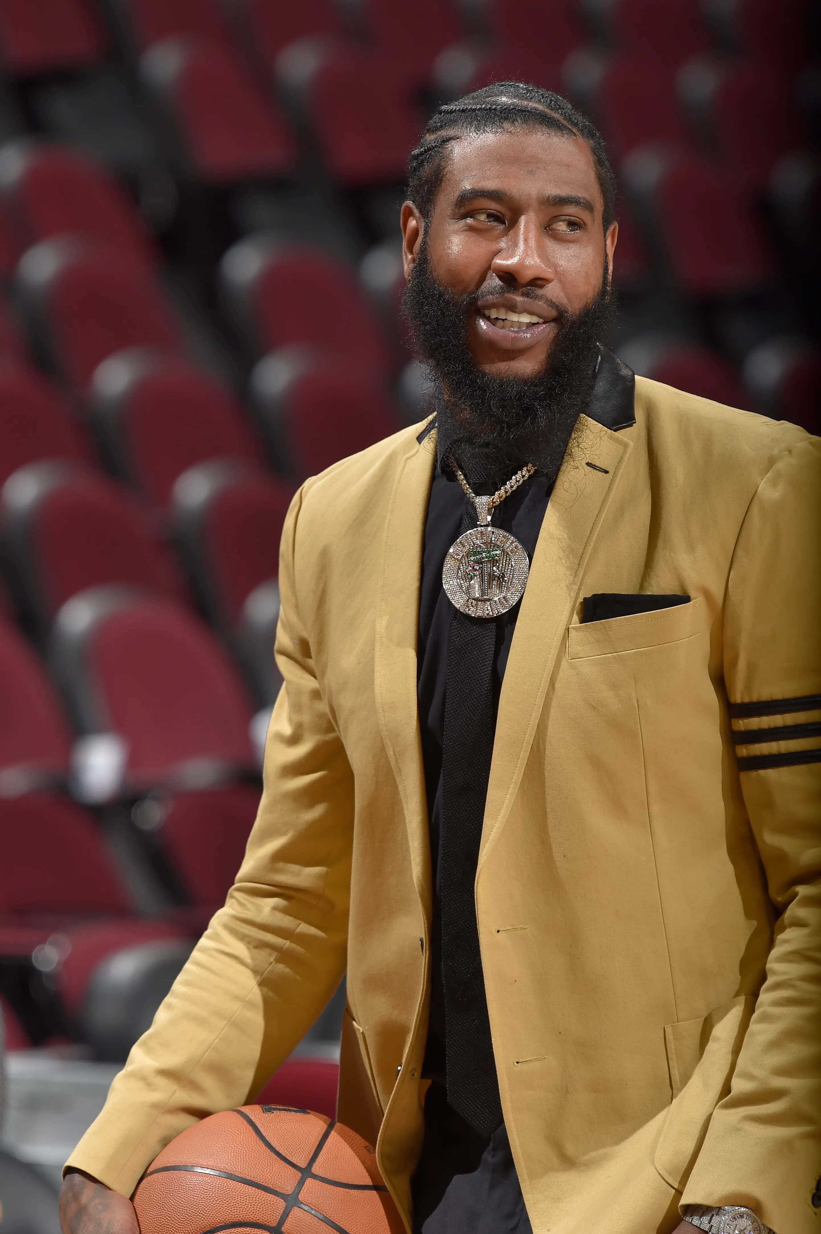 Iman Shumpert smiles while holding a basketball.
