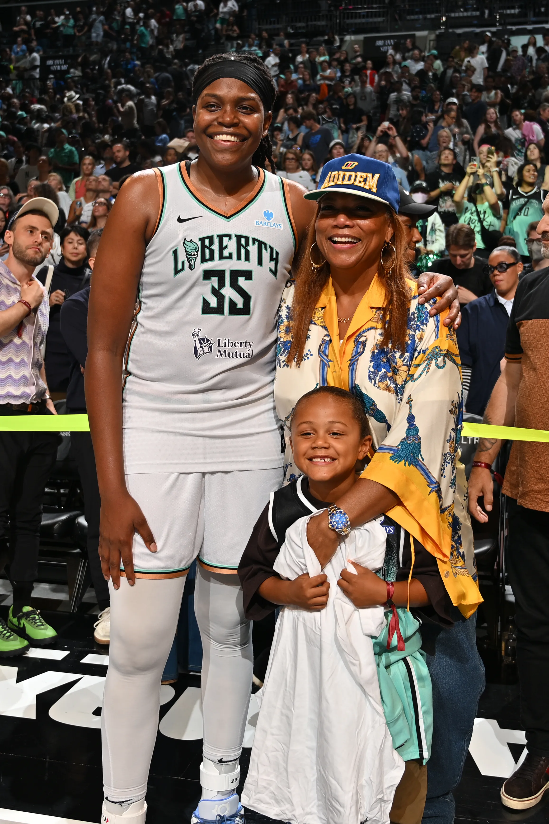 Jonquel Jones, Queen Latifah, and a child pose for a photo.
