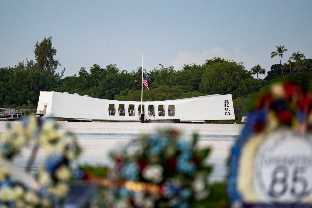 The USS Arizona Memorial with an American flag flying at half-staff.