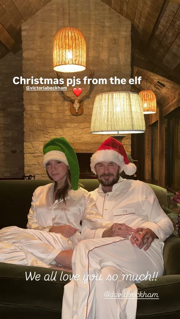 Victoria and David Beckham in white Christmas pajamas, Victoria wearing a green elf hat and David wearing a red Santa hat.