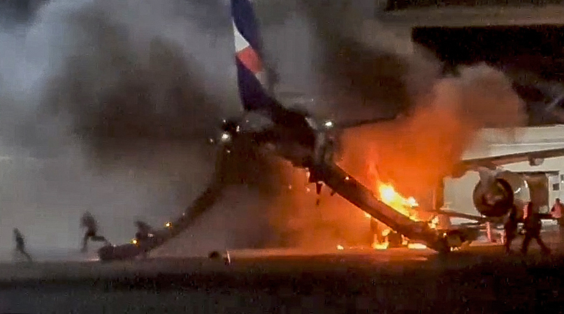 Flames and smoke rising from a Latam Airlines plane on the tarmac at Guarulhos International Airport in Sao Paulo state, Brazil.