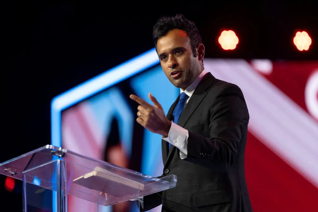 Vivek Ramaswamy speaking at a podium during AmericaFest.