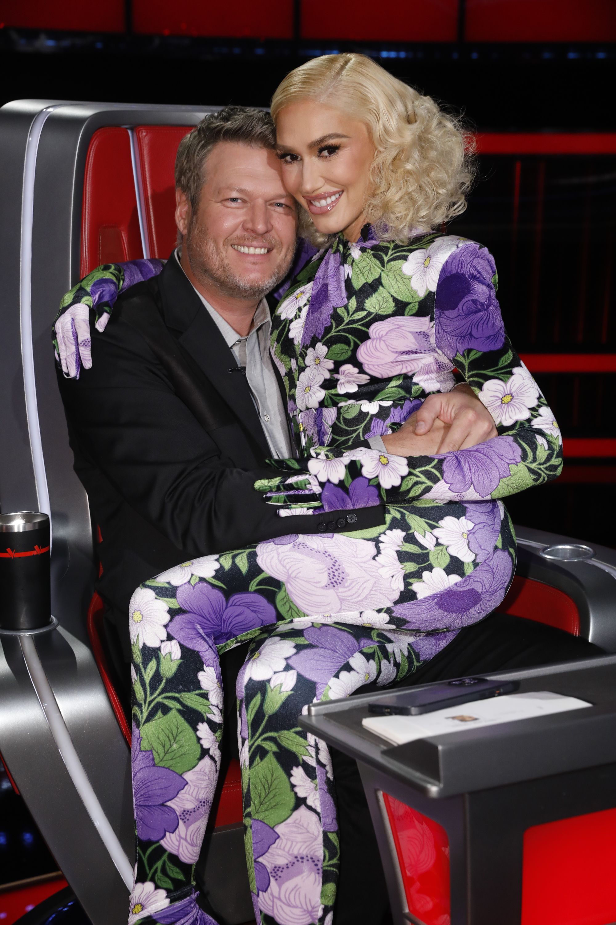 Gwen Stefani sitting on Blake Shelton's lap on The Voice set.