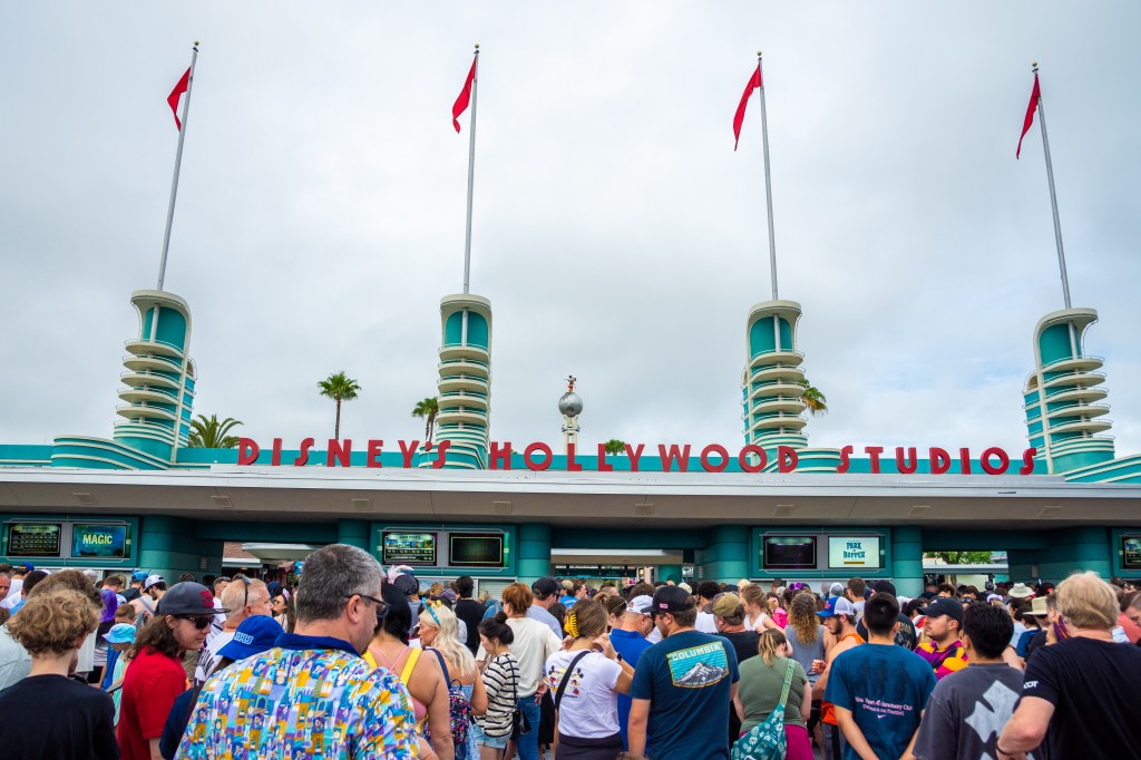 The entrance to Disney's Hollywood Studios in Orlando, Florida, with a crowd of people gathered.