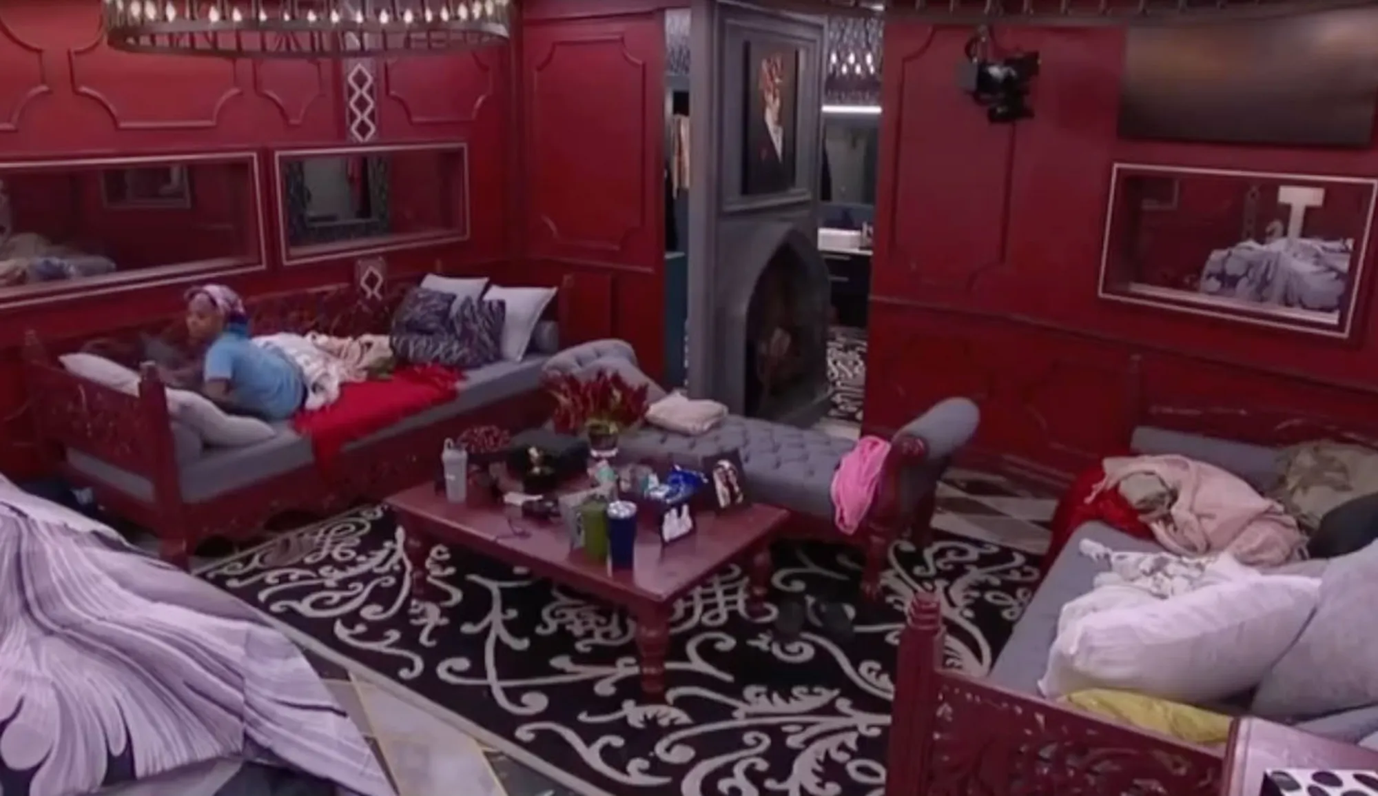 Mickey Lee lying on a bed in a red room.