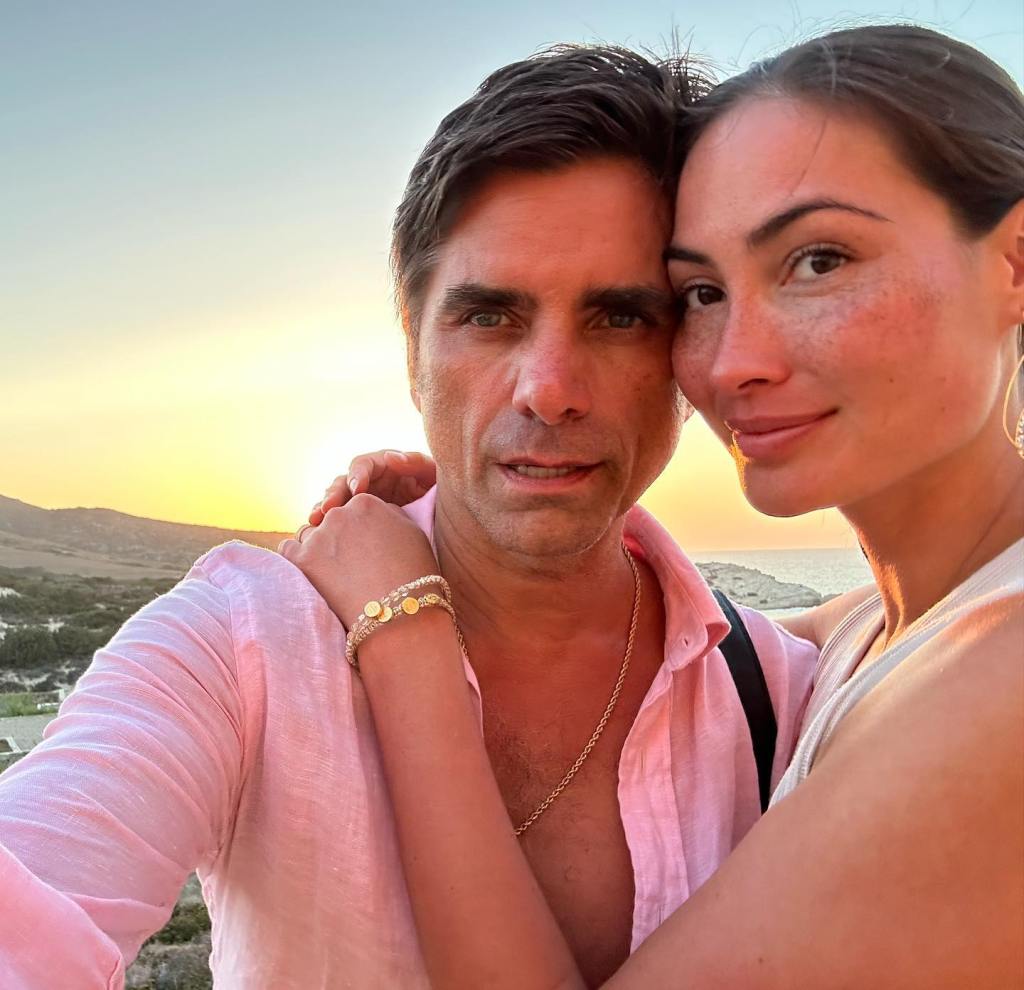 John Stamos and Caitlin Stamos embracing at sunset.