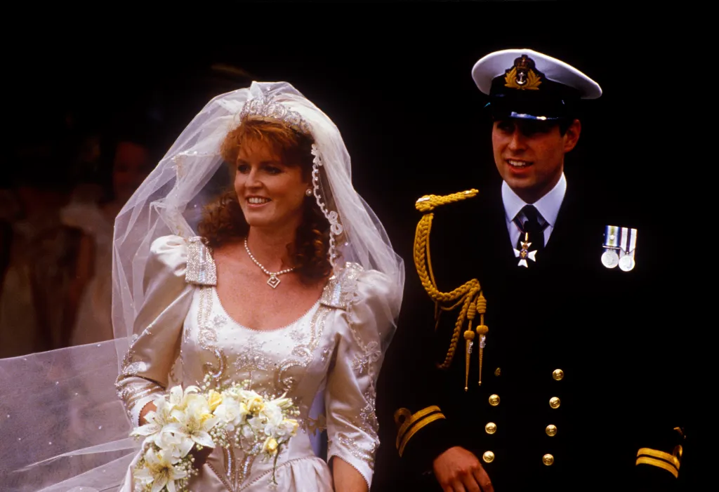 Prince Andrew, Duke of York, in naval uniform, and Sarah Ferguson, in her wedding dress, smiling on their wedding day.