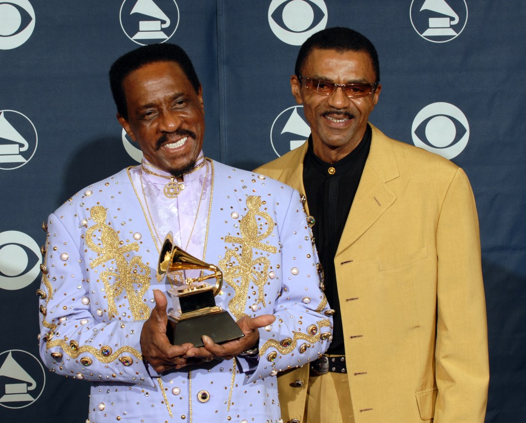 Ike Turner holding a Grammy Award with his son, Ike Turner Jr., standing beside him.